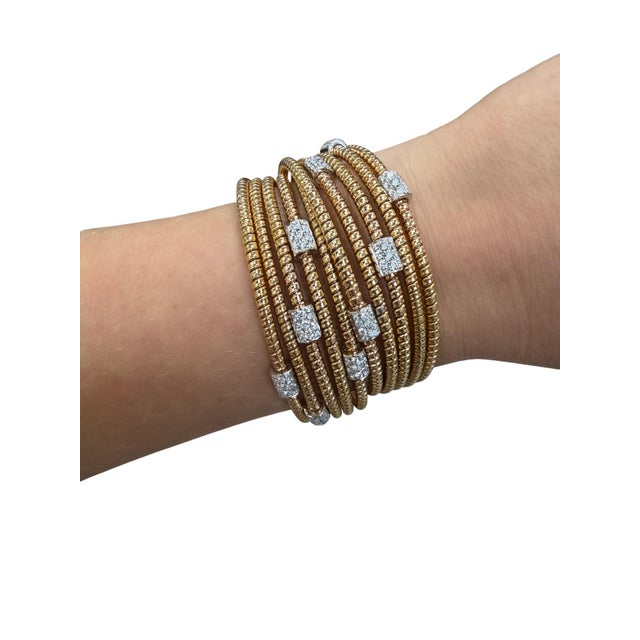 This stylish bracelet is in a wrap design with rose gold bands and white gold stations set with round brilliant cut...