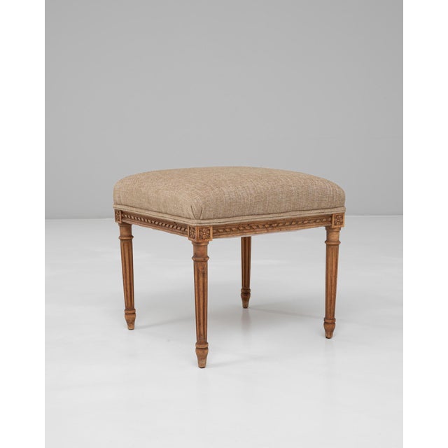 This 1900s French Louis XVI upholstered stool exemplifies the refined symmetry and classical detailing associated with the...