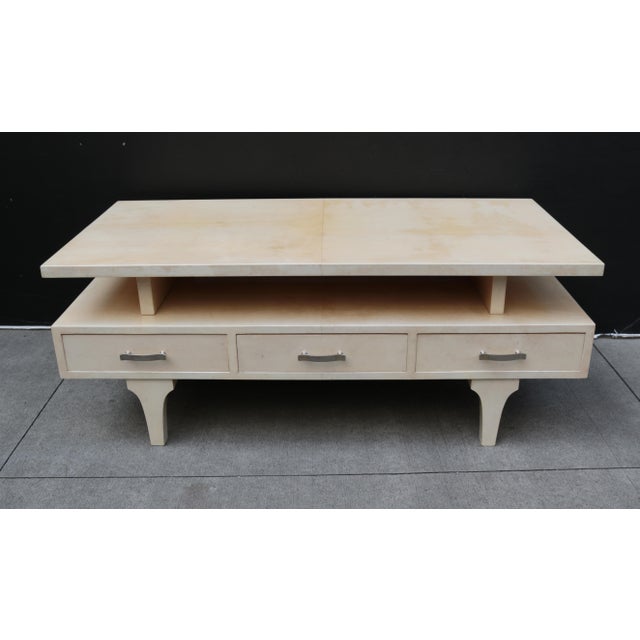 An Italian modernist cocktail table by Aldo Tura. Lacquered parchment with patinated brass pulls. Drawers on one side only.