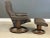 A modern brown leather reclining lounge chair and ottoman made by Ekornes Stressless. Minor cat scratches on the top of...