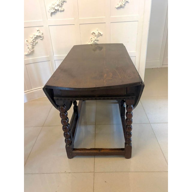 A rare and characterful oak gateleg dining table of early English origin retaining a beautifully mellowed surface and...