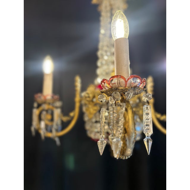 A four-light chandelier in gilt bronze, with a central structure adorned with beads and cut glass pendants. The upper...