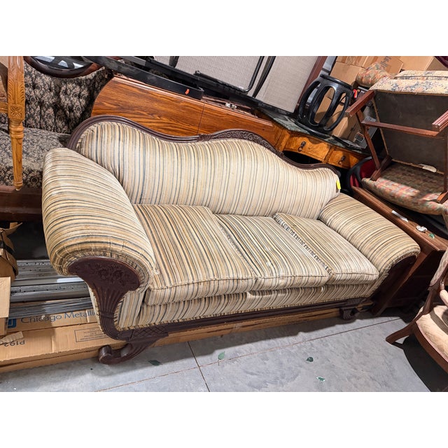 Victorian sofa with three piece cushion seating. Carving detail on scroll arms.