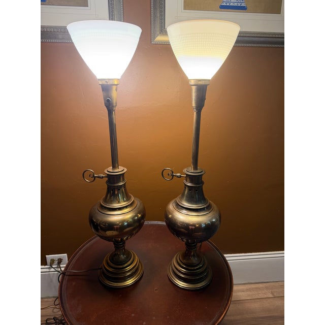 This vintage pair of Stiffel table lamps epitomizes mid-century Hollywood Regency elegance. Featuring a classical brass...