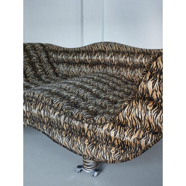 Striking postmodern sofa with a biomorphic silhouette and bold tiger-stripe patterned velour upholstery. The spring legs...