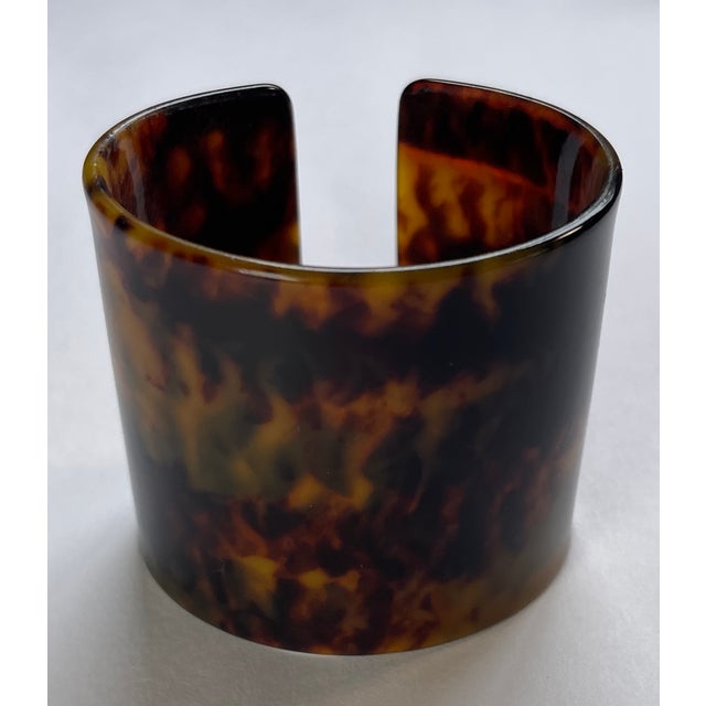 This is a classic cuff made of acrylic resin in a handsome faux tortoise pattern. 2 ⅛W x 1 ¾D x 1 ⅞H circumference 6 ⅜