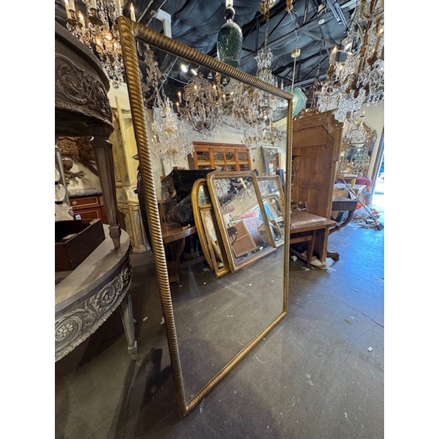 The large scale 19th Century Giltwood Transitional Mirror is a luxurious and elegant piece that embodies the style of the...