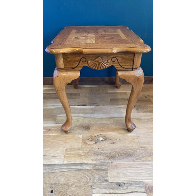 This beautifully crafted vintage solid oak side table features elegant carved shell accents and detailed etched cutouts. A...