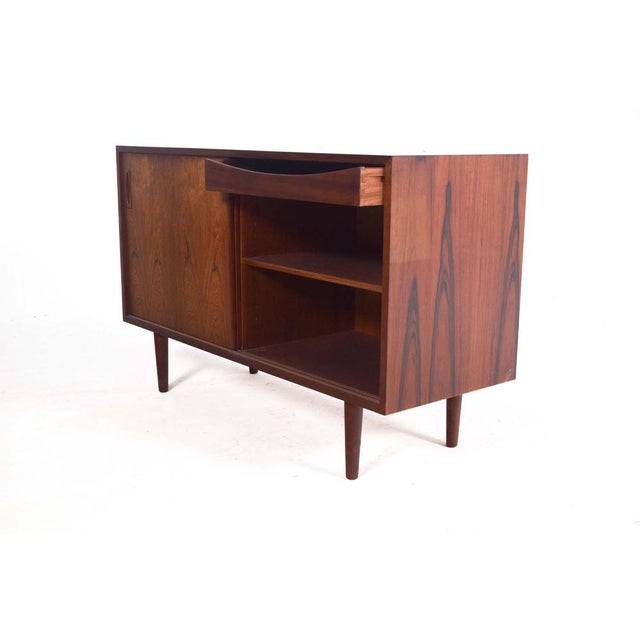 Elegant sideboard, manufactured in Denmark in the 1950s, showcases the refined craftsmanship and timeless design of mid-...
