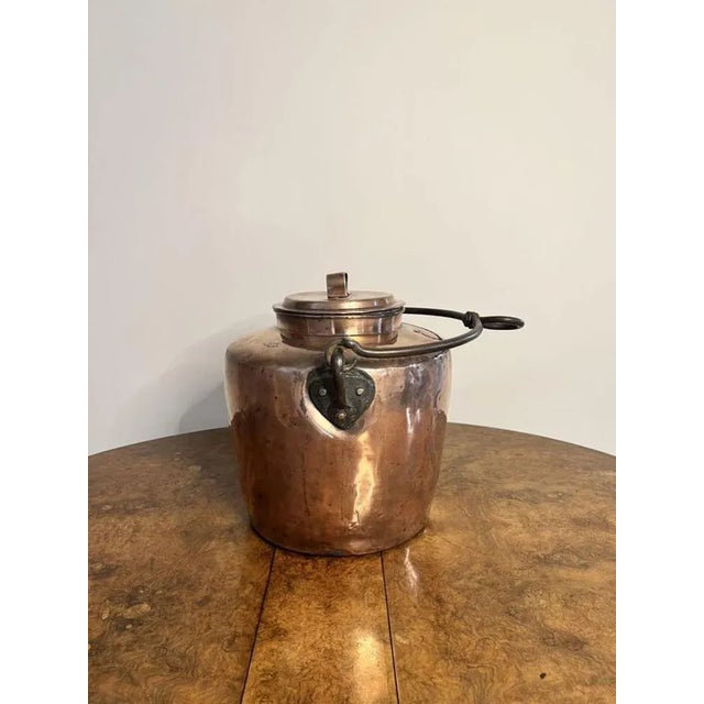 Large antique George III quality hanging copper water urn, having the original iron swing handle to the top above a large...