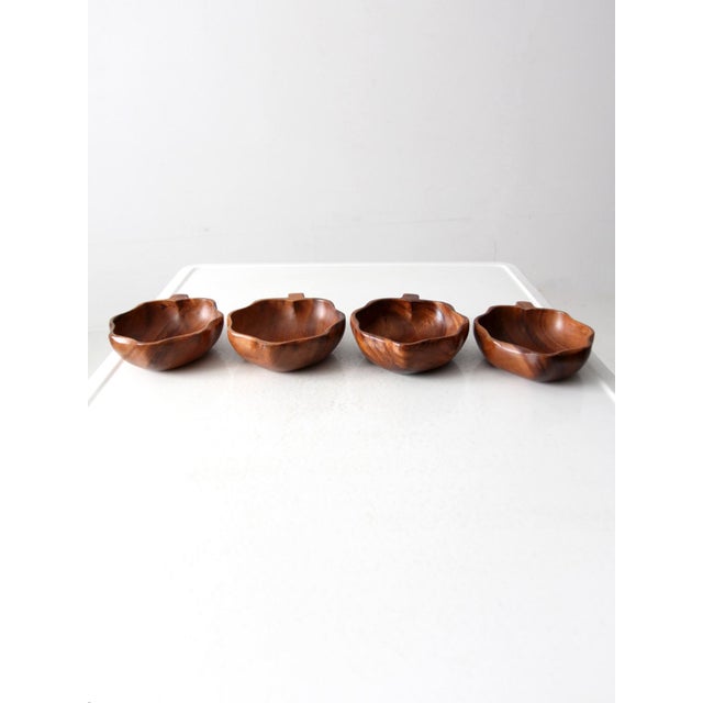 Add a touch of mid-century charm to your table with this set of four vintage monkey pod wood leaf-shaped bowls. Hand-...