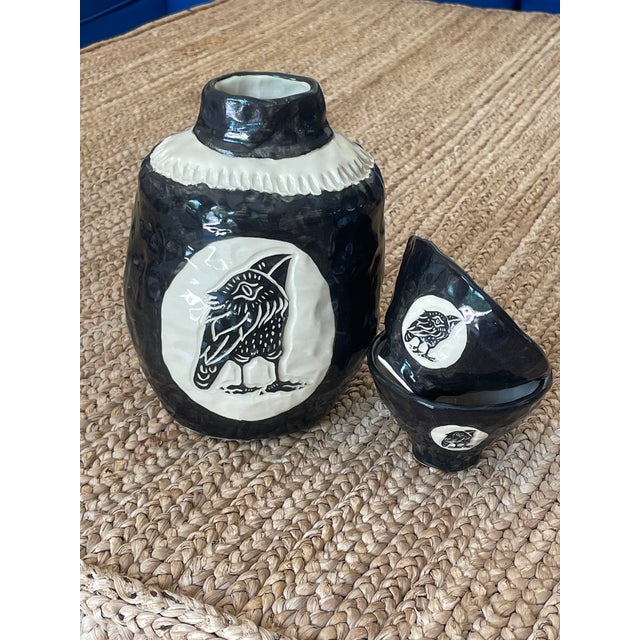 Sake Bottle with Set of Two Cups Crow Spirit Sake Set Size is approximately: 7'' tall x 4.5'' x 3.5'' bottle, cups are...