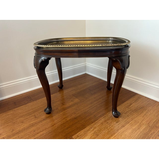 An elegant vintage Queen Anne style mahogany tray top side table. Table features a rectangular top with rounded corners...