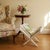 This vintage folding magazine rack combines a white-painted wooden frame with woven cane panels, curved upper edges, and...