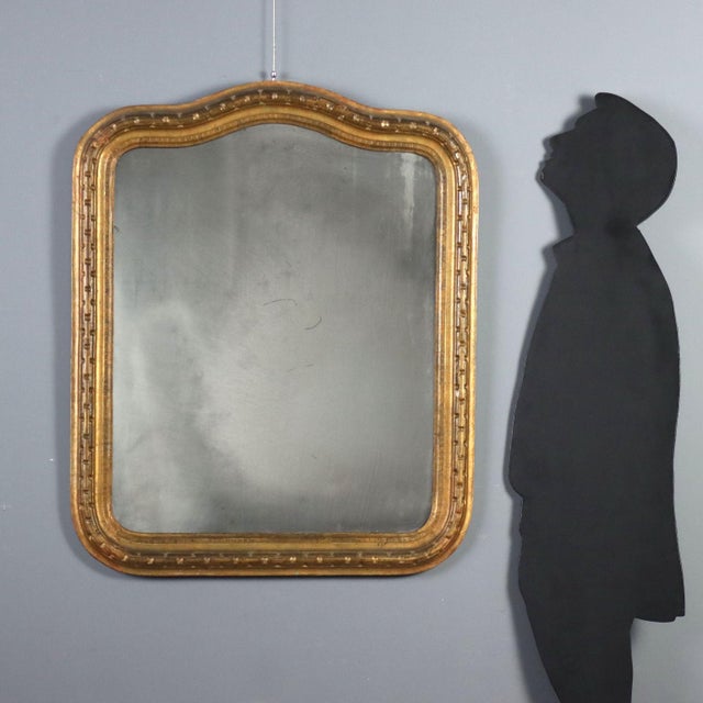 Carved and gilded wood mirror dating back to the late 19th century, originating from Italy. The frame features elegant...