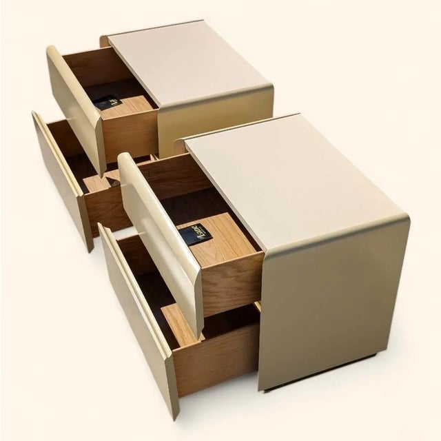 Bring timeless design into your home with this pair of Postmodern nightstands in a creamy beige lacquer finish. Design...