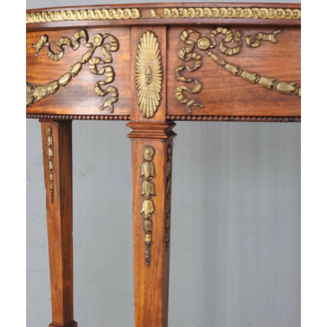 This French oval table from the late 19th century is accented with detailed ormolu on the sides and legs. Tapered legs...