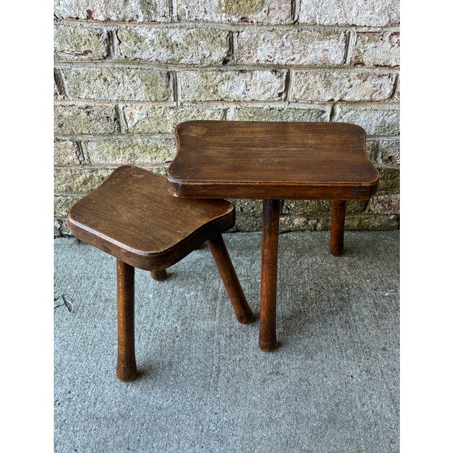 Pair of small scale wooden nesting side tables from France. The top of larger table is a slightly irregular shape, making...