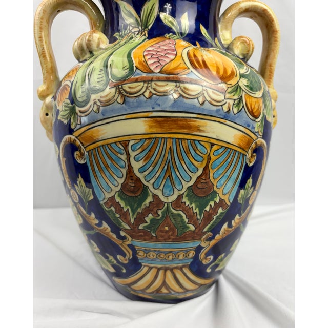 Vintage Italian majolica-style amphora vase featuring a rich cobalt blue glaze with hand-painted fruit and scrolling...