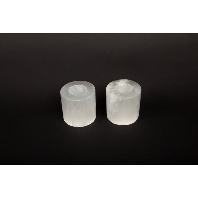 This pair of luminous selenite votive holders is a captivating addition to any space, designed to hold standard tea light...