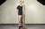 A tall cylindrical floor lamp repurposed from an industrial wooden wallpaper and textile printer in muted silver-grey and...