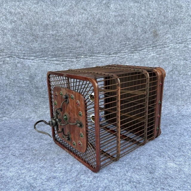 Add a touch of exotic elegance to your space with this vintage-style Chinese birdcage. Crafted from wood with a warm,...