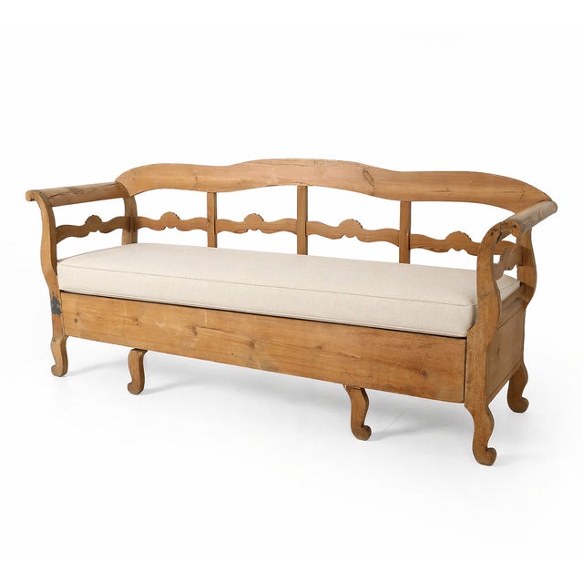Charming antique Swedish pine bench featuring a gently scalloped backrest, shaped arms, and classic cabriole legs. Crafted...