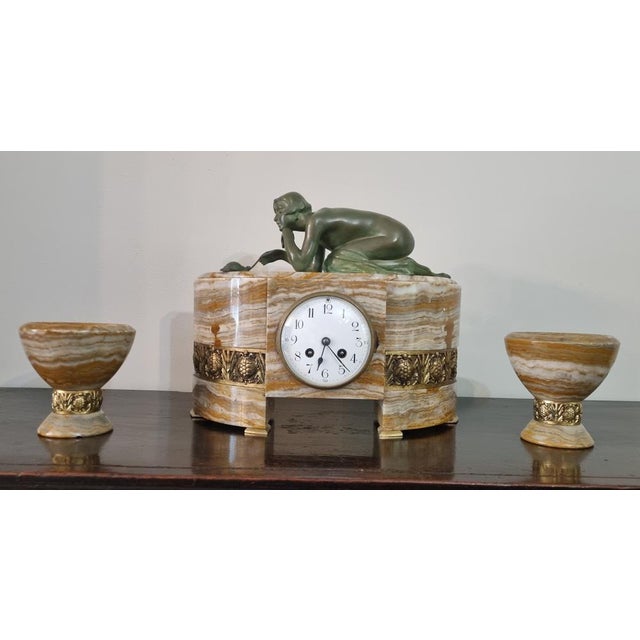 Introducing "patience," a captivating early art deco figural clock garniture set , made by the a renowned sculptor of the...