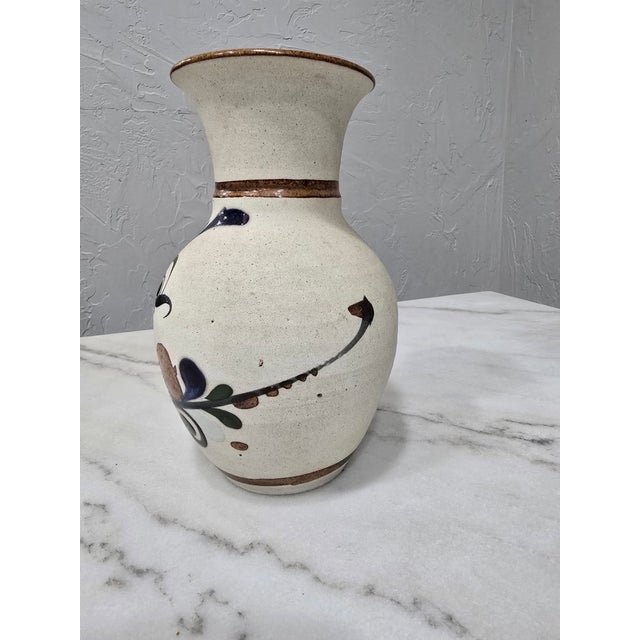This mid-century style stoneware vase features a warm, speckled sandstone finish. It is intricately decorated by hand with...