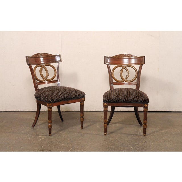 A French set of four finely detailed dining chairs from the mid-20th century. These mid-century chairs from France,...