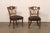 A French set of four finely detailed dining chairs from the mid-20th century. These mid-century chairs from France,...