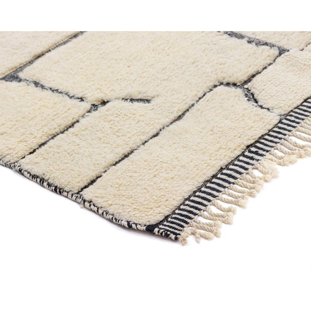 Sophisticated hand-knotted wool rug in Ivory, detailed with a distinctive hand-woven Charcoal linear pattern, forming an...