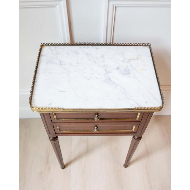 Elegant Louis XVI–style side table crafted in mahogany during the 20th century, reflecting the refined neoclassical...