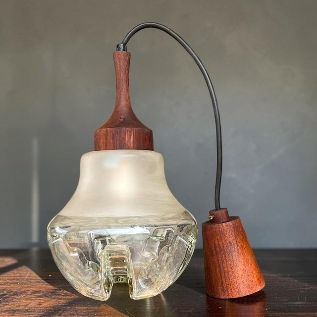 A striking vintage pendant light combining sculptural glass and linseed oil treated teak wood. Linseed oil is the most...