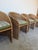 A beautiful set of four 1970s vintage wicker dining chairs featuring a classic barrel back silhouette with an organic,...