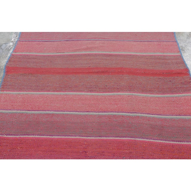 Handwoven in wool circa 1950-1960, this 5x5 vintage Kilim, woven in the tradition of a Frazada textile, is a nuanced...