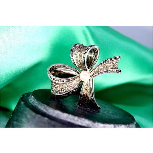 Gold and Silver Bow-Shaped Brooch with Diamond Flakes, in Very Good conditions. Designed 1980 to 1989 This piece has an...