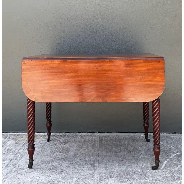 This elegant vintage mahogany drop leaf table is a refined example of mid-20th-century craftsmanship, offering timeless...