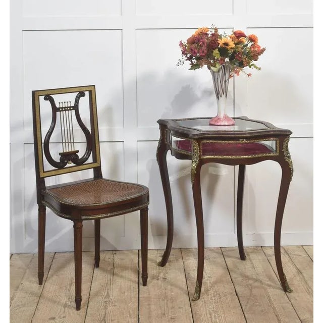 A refined French bijouterie table in the Louis XV style, beautifully crafted from mahogany and embellished with ornate...