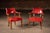 Matching pair of classic captain's armchairs upholstered in richly patinated burnt orange leather with brass nailhead trim...
