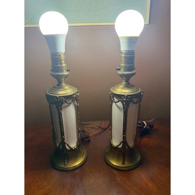This vintage pair of French Empire brass and milk glass table lamps exudes elegance and charm, perfect for any space...