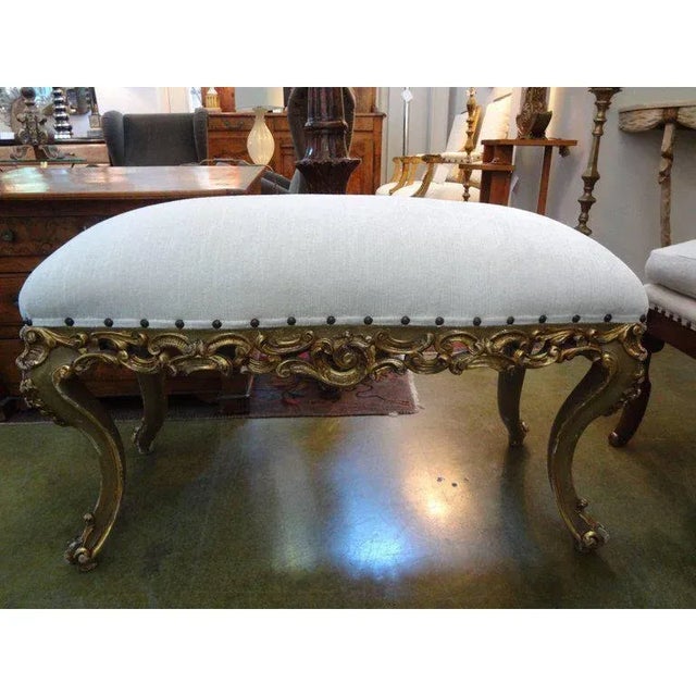 Stunning Italian gilt wood bench with exaggerated legs. This 1920s Italian bench was taken down to the frame and...