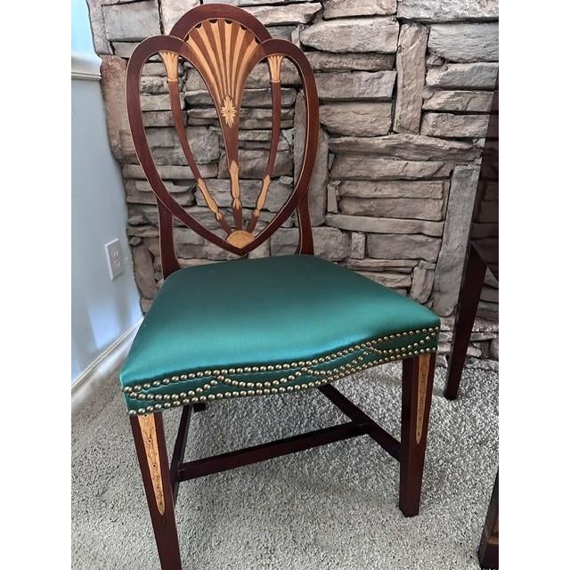 The chairs were originally purchased from Baker Furniture. The chair is a Hepplewhite style mahogany shield-back armchair...