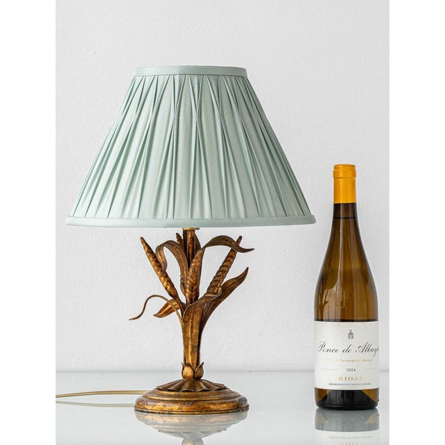 An elegant French gilt metal table lamp, circa 1960s, in the Coco Chanel style with the iconic wheat sheaf motif. A...