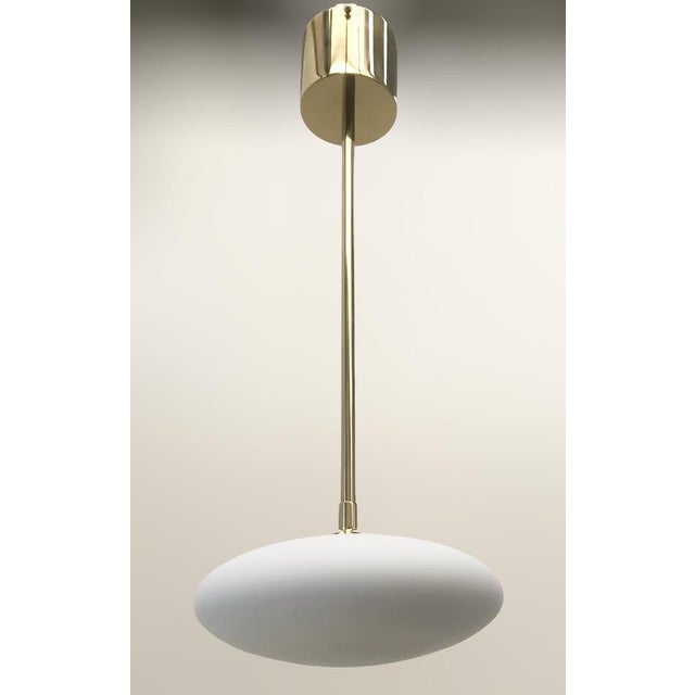 Italian pendant with matte white Murano glass shade mounted on solid brass frame in lacquered polished brass finish / Made...