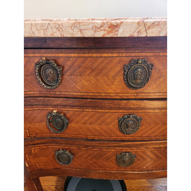 OverviewFor sale is an elegant, antique Louis XVI-style marble-top commode. This striking three-drawer chest features a...