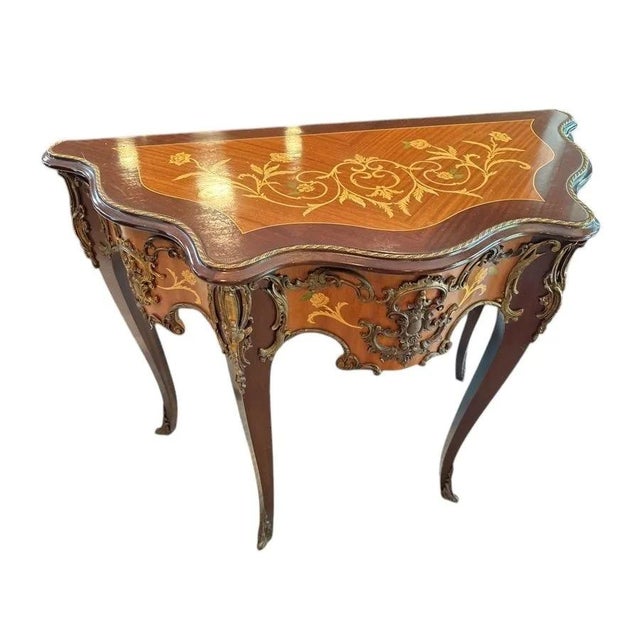 Elegant Louis XV-style console with a serpentine floral-marquetry top, an inlaid apron, cabriole legs and abundant gilt...