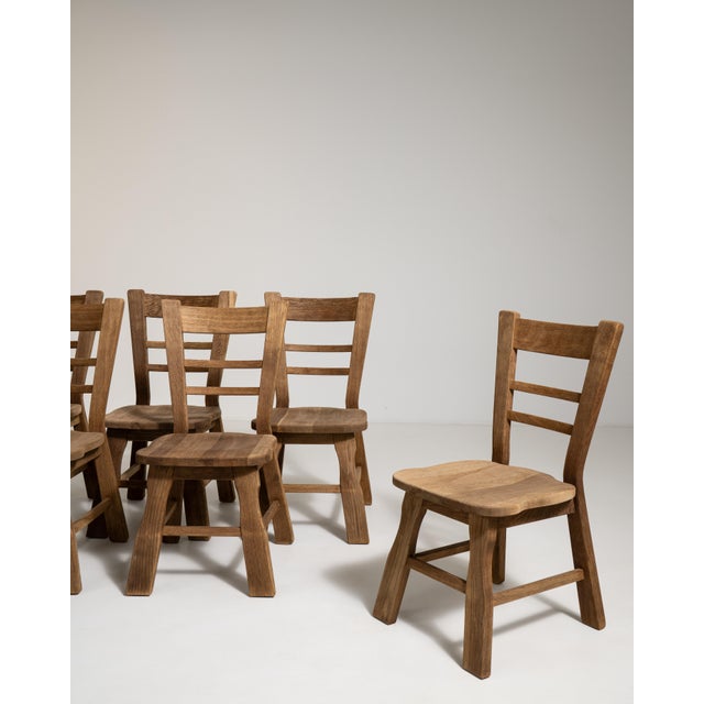 A distinguished set of six French oak dining chairs from circa 1970, rendered in the clean, purposeful spirit of Mid-...