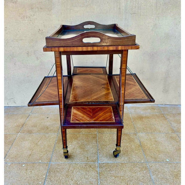 French Art Deco folding bar cart from the 1930s, featuring elegant walnut veneer with geometric marquetry decoration. The...