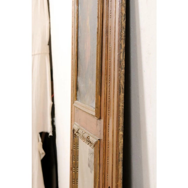 A tall French trumeau wood mirror, with oil painting framed atop, from the turn of the 18th and 19th century. This antique...